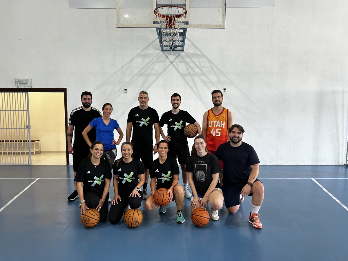 xelerate.tech colleagues in team shirts posing with basketballs in a sports hall