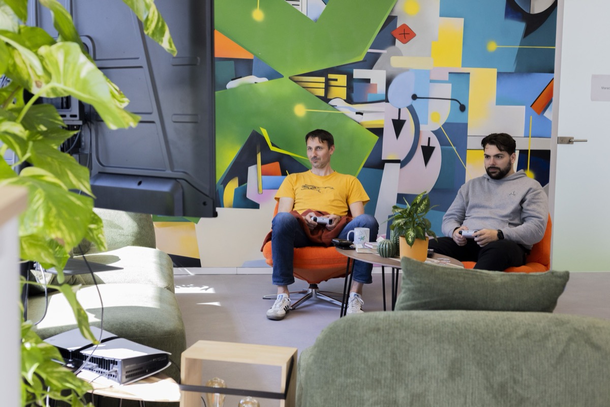 Two colleagues playing video games in the xelerate.tech office lounge